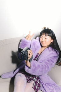 VantagePoint Marketing - Woman recording herself with camera wearing purple coat